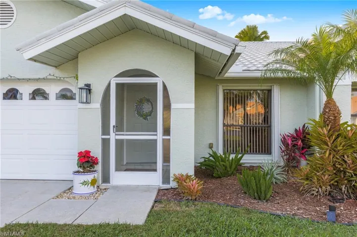 Doorway to property with an attached garage and stucco siding
