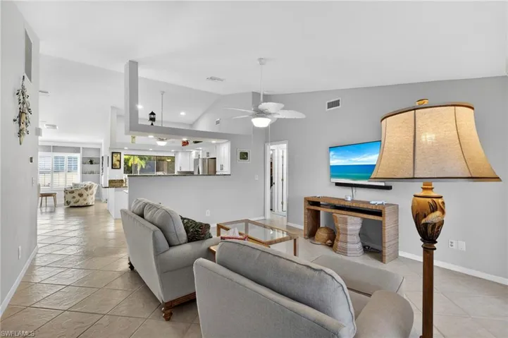 Living area featuring vaulted ceiling, a ceiling fan, and recessed lighting