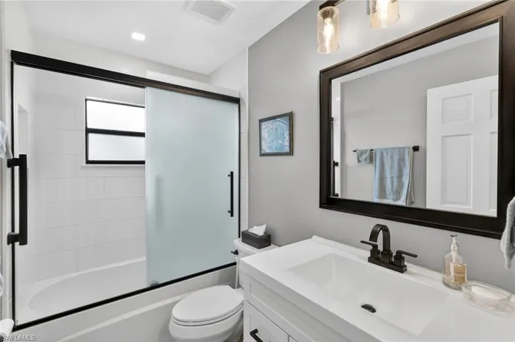 Bathroom featuring vanity and enclosed tub / shower combo