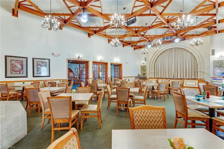 Dining area with a towering ceiling, coffered ceiling, carpet flooring, and beam ceiling