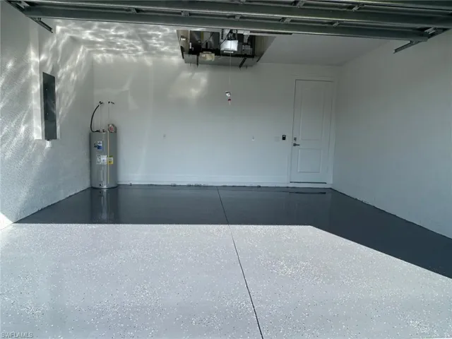 Garage featuring water heater and electric panel