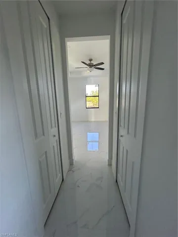 Hall featuring marble finish floors and baseboards
