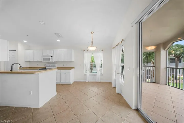 Kitchen and dining area featuring white cabinetry, light countertops, and tile flooring