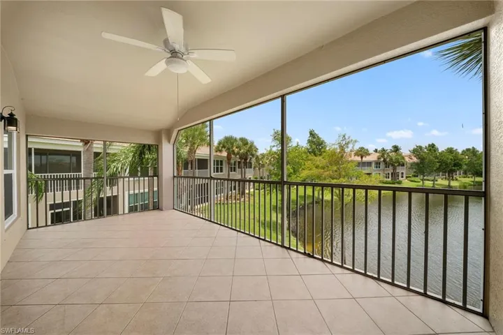 Screened balcony featuring light-toned tile flooring and a ceiling fan