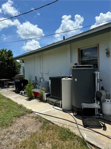 View of side of property featuring a cooling unit and stucco siding