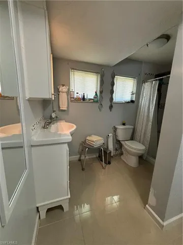 Bathroom with vanity, a shower with curtain, and tile patterned flooring