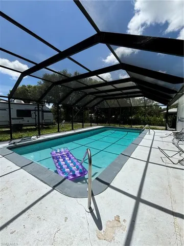 Outdoor pool with a patio area and glass enclosure