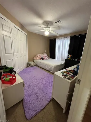 Bedroom featuring a textured ceiling, a closet, and a ceiling fan