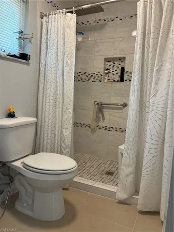 Full bath featuring a stall shower and a textured wall