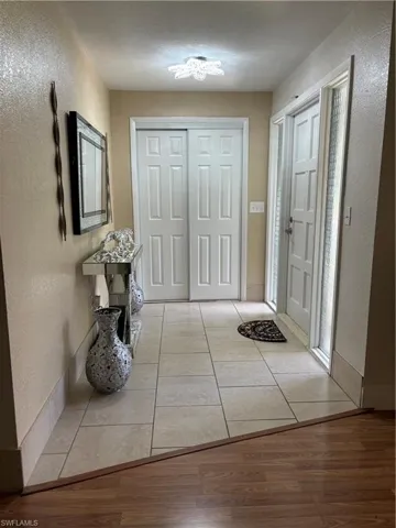 Doorway to outside with a textured wall and wood finished floors