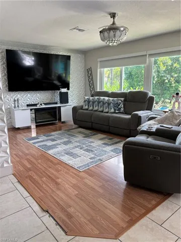 Living area with light tile patterned flooring and a textured ceiling