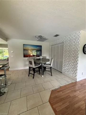 Tiled dining area with a textured ceiling and baseboards