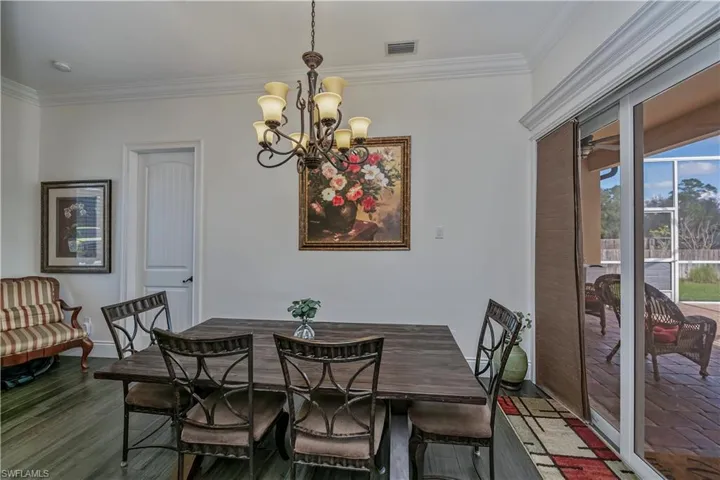 Dining area with notable chandelier, wood-type flooring, and ornamental molding