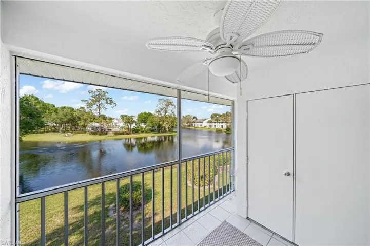 Unfurnished sunroom featuring a ceiling fan and a water view