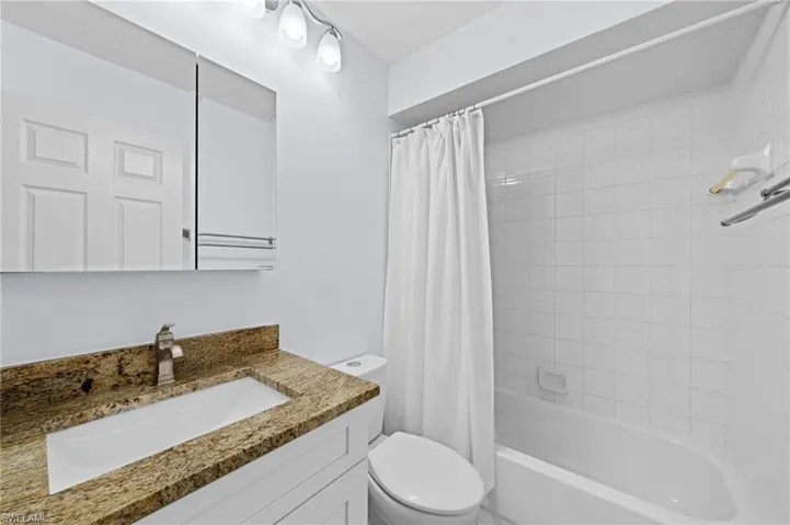 Full bath featuring shower / bath combination with curtain and vanity