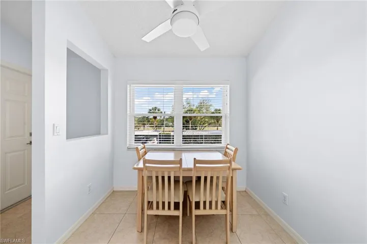 Dining area with light tile patterned floors and a ceiling fan