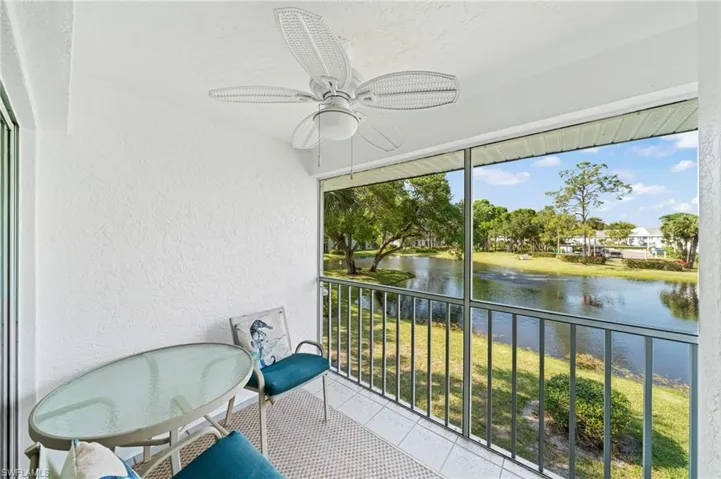 Unfurnished sunroom featuring ceiling fan, a balcony, and a water view