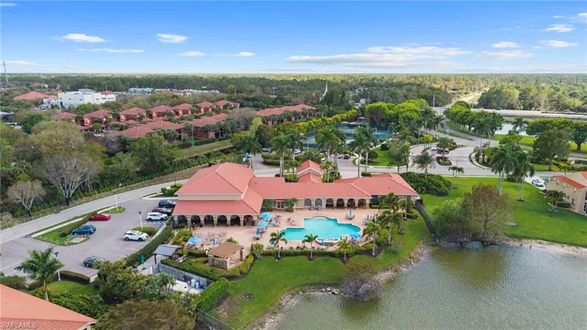 Aerial perspective of suburban area with a pool and a large body of water
