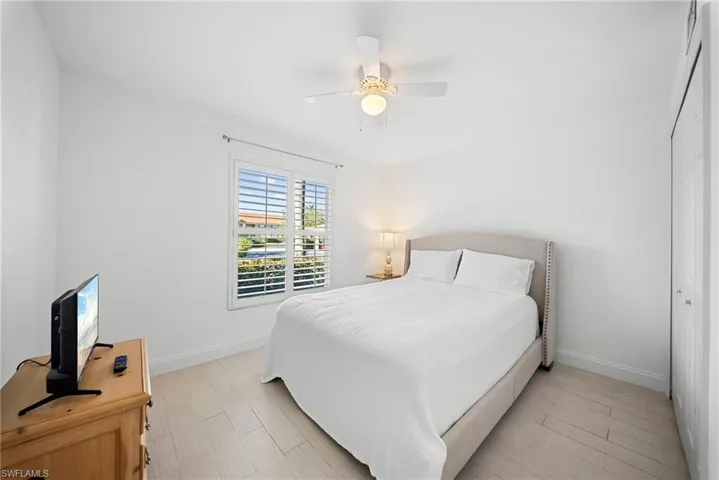 Bedroom with ceiling fan, wood finish floors, and a closet