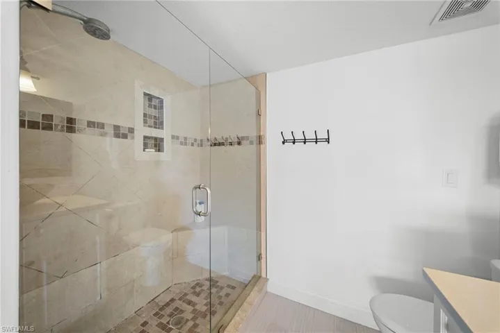 Full bath featuring a stall shower and vanity