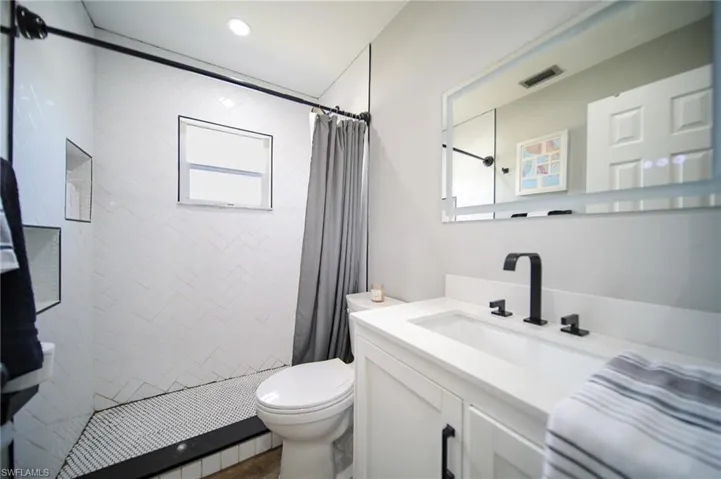 Bathroom featuring vanity and tiled shower