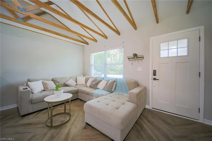 Living room featuring beam ceiling and high vaulted ceiling/ techo alto 11 pies