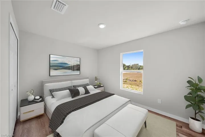 Bedroom with visible vents, baseboards, and wood finished floors