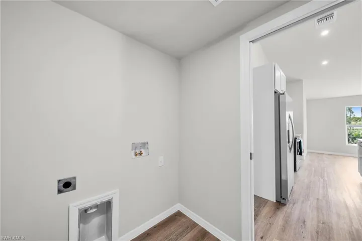 Laundry area with visible vents, washer hookup, laundry area, light wood-style flooring, and hookup for an electric dryer