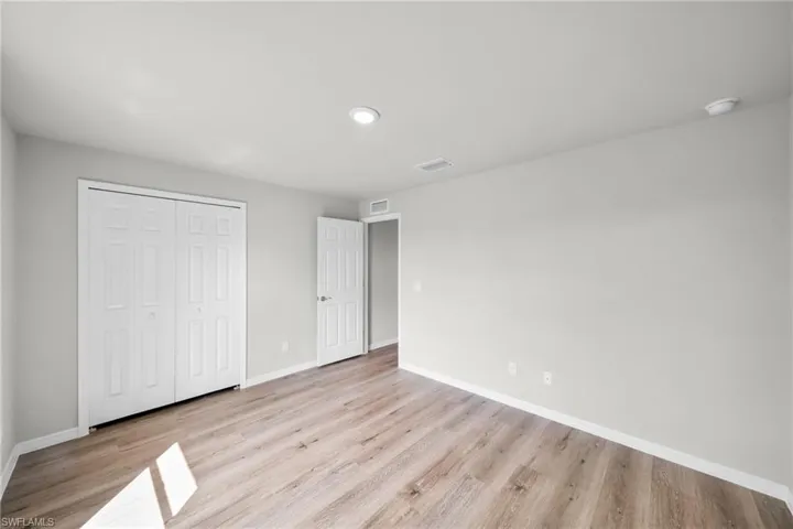 Unfurnished bedroom featuring visible vents, baseboards, and light wood-style floors
