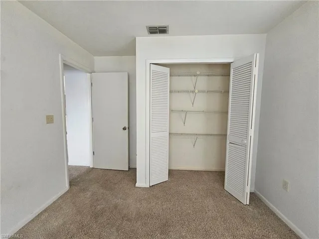 Unfurnished bedroom featuring carpet floors, a closet, and baseboards