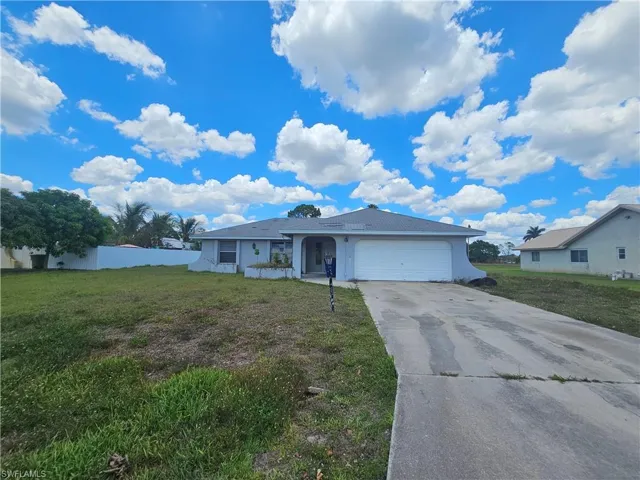 View of front of property with stucco siding, concrete driveway, an attached garage, and a front lawn
