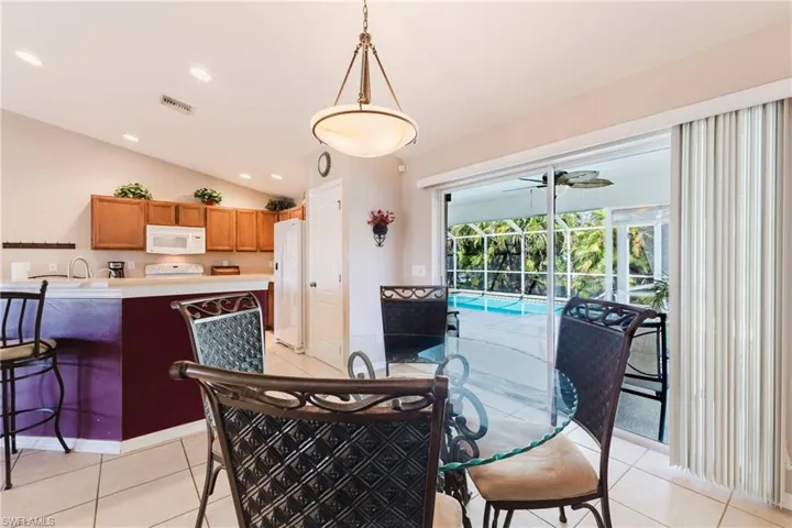 Roomy dining area adjacent to the kitchen and overlooking the pool.