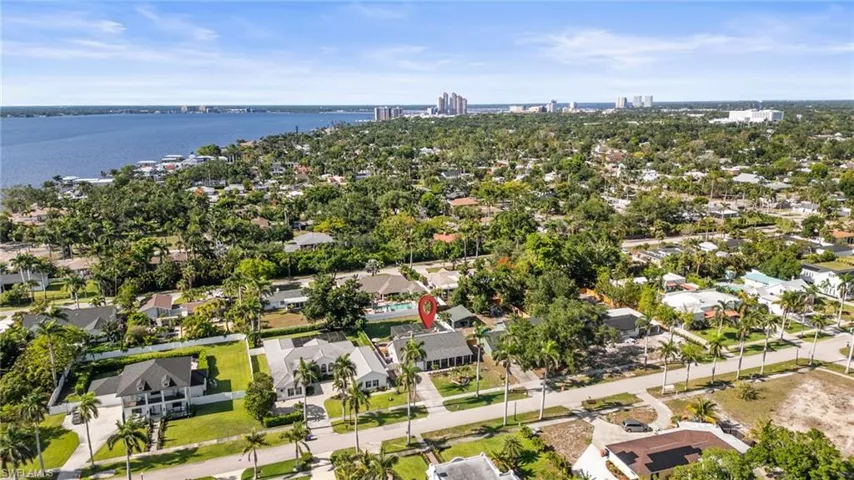 Aerial view of property and surrounding area featuring a nearby body of water and nearby suburban area