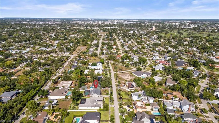 Aerial view of property and surrounding area featuring nearby suburban area