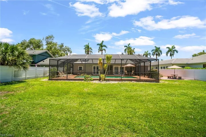 Rear view of house with a lanai and a separate patio