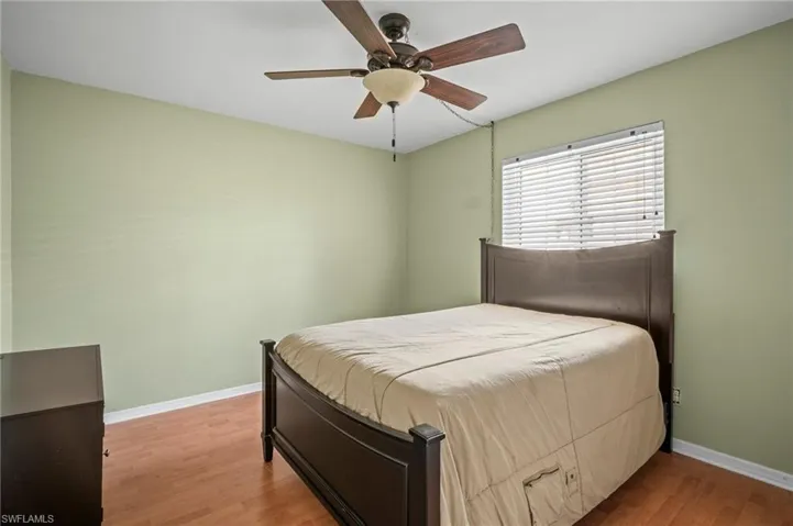 Bedroom featuring wood finished floors, baseboards, and ceiling fan