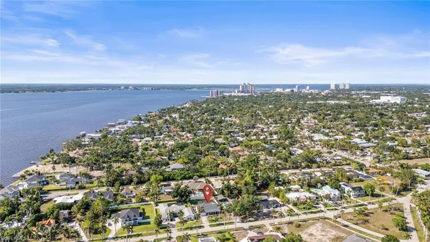 Aerial view of property's location featuring a nearby body of water and nearby suburban area