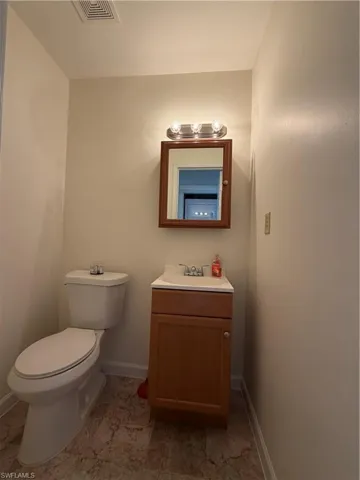 Full bathroom featuring a single vanity with wood-finish cabinetry, white countertop, and integrated sink