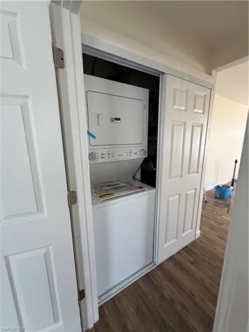 Dedicated laundry closet featuring a white stackable washer and dryer unit
