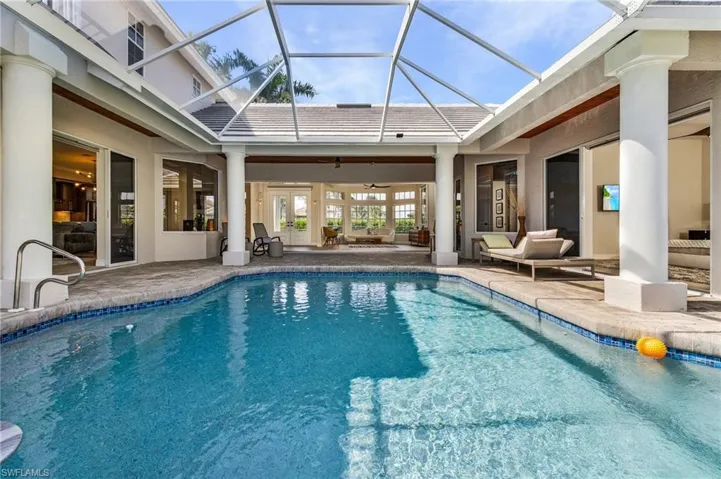 Swimming pool with a patio, ceiling fan, an outdoor hangout area, french doors, and glass enclosure