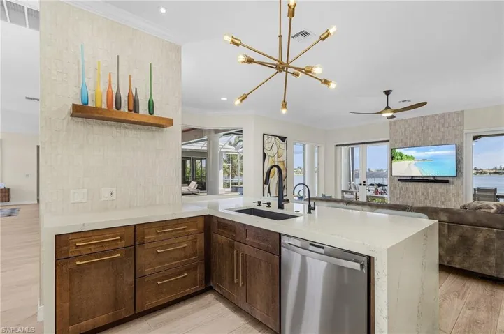 Kitchen with dishwasher, open floor plan, light wood finished floors, a peninsula, and healthy amount of natural light