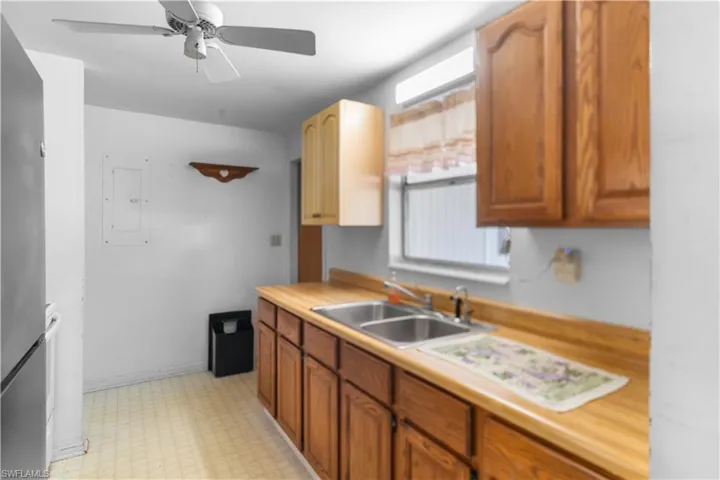Kitchen with electric panel, ceiling fan, and sink