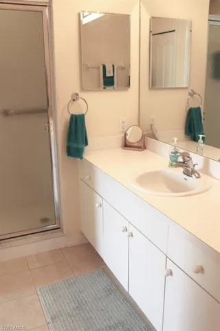 Bathroom with a shower stall, vanity, and light tile patterned floors
