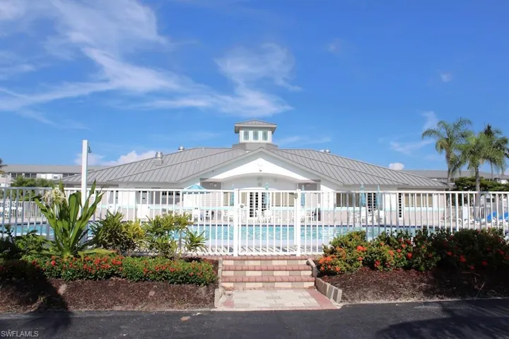 View of building exterior featuring a community pool