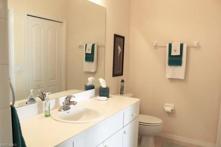 Bathroom with vanity, a closet, and light tile patterned floors