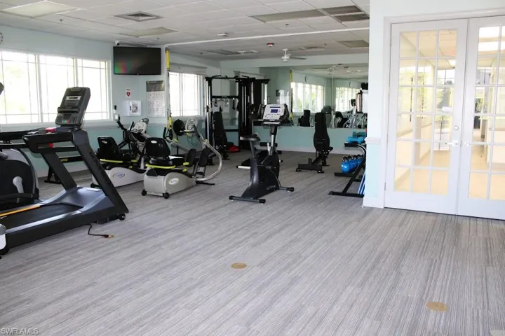 Gym featuring french doors, a paneled ceiling, and carpet flooring