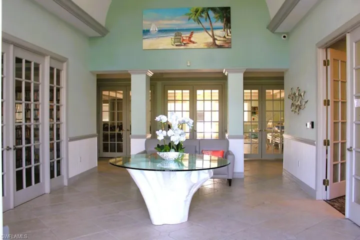 Dining room with french doors, a high ceiling, a wainscoted wall, and tile patterned flooring