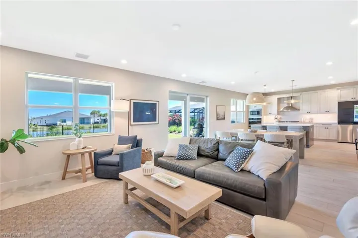 This open-concept living and dining area blends modern design with relaxed elegance. Warm wood tones, soft neutral walls, and natural light create a welcoming flow between the dining table, lounge space, and kitchen beyond. Clean lines and layered textures make it perfect for both casual gatherings and stylish entertaining—a space that feels effortlessly connected and inviting.