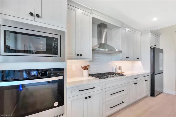 This kitchen pairs sleek functionality with modern farmhouse charm. Crisp white cabinetry, designer hardware, and stainless-steel appliances create a bright, polished look. A custom range hood, built-in oven and microwave, and quartz counters complete the space—clean, efficient, and made for both everyday living and effortless entertaining.