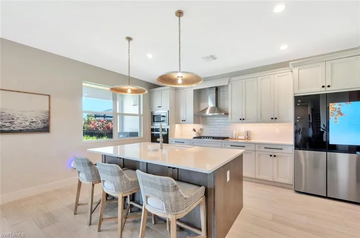 This kitchen pairs sleek functionality with modern farmhouse charm. Crisp white cabinetry, designer hardware, and stainless-steel appliances create a bright, polished look. A custom range hood, built-in oven and microwave, and quartz counters complete the space—clean, efficient, and made for both everyday living and effortless entertaining.